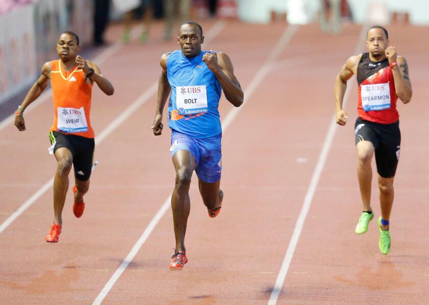 Jamaica's Usain Bolt (C) competes next to his compatriot Warren Weir (L) and Wallace Spearmon of the U.S. in the men's 200m race during the Athletissima Diamond League meeting in Lausanne August 23, 2012.    REUTERS/Valentin Flauraud (SWITZERLAND  - Tags: