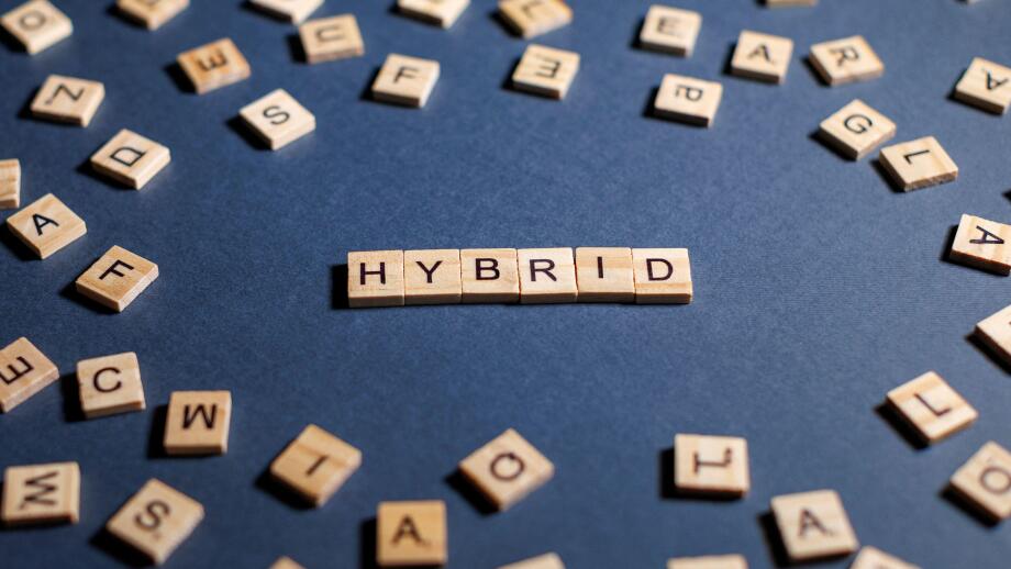 word hybrid on a dark background spelled with wooden letters