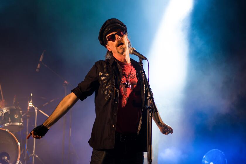 Rock lead singer on stage wearing a hat and sunglasses