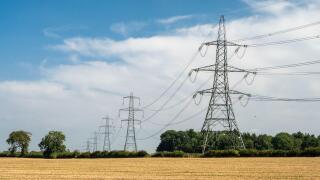 National Grid power lines cross arable fields near Nettleton in England's Cotswolds Hills.
