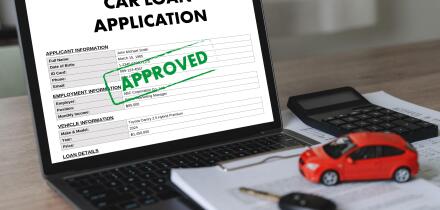 Online car loan application form displayed on laptop with calculator, vehicle model, financial documents, and car key for digital financing, banking a