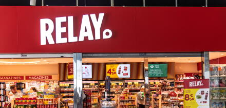 The storefront of a Relay press and convenience store, displaying magazines, snacks and souvenirs, at Barcelona Airport.