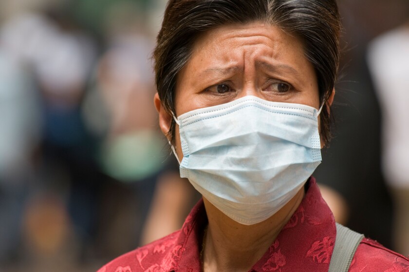 A woman wearing a surgical mask as protection against swine flu Hong Kong May 2009