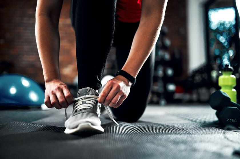 Runner, hands and tying shoes for training, fitness and exercise or running with sneakers, fashion and getting ready. Person or athlete with laces and