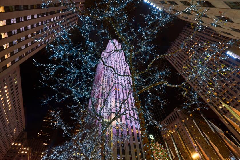 Night view of Rockefeller Center skyscrapers and Plaza illuminated with Winter holiday lights. Manhattan, New York City