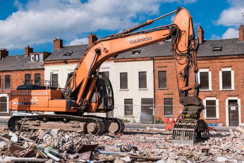 A demolition excavator on an inner city site where houses are being demolished.