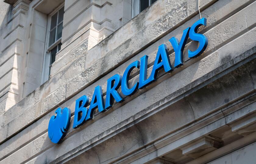 Large sign outside a branch of Barclays Bank in a city, UK.