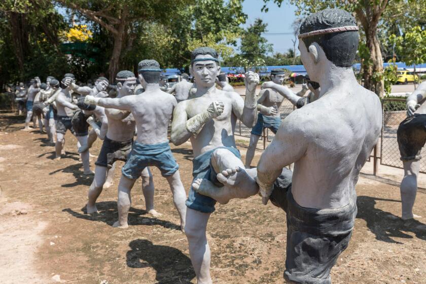 Fighting men statues kick boxing, Muay Thai, at Wat Bang Kung, Bangkok, Thailand
