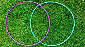 Two overlapping hula-hoops on grass. A Colorful, stylized VENN figure. Two intersecting circles. Contours. Stylish. Minimalist