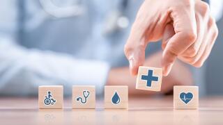 Hand arranging wood block with healthcare medical icon. Health insurance - concept.