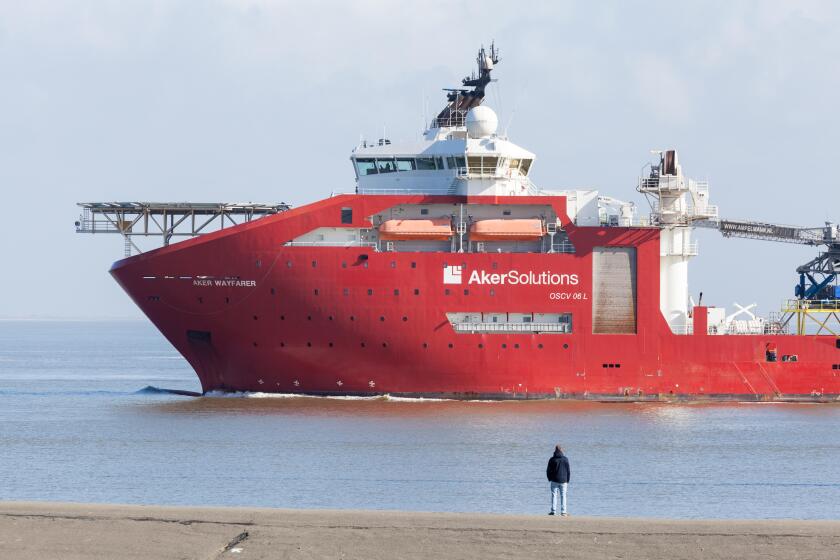 A man watching a Norwegian Deepwater Subsea Equipment Support Vessel (SESV), Aker Wayfarer, depart Eemshaven in the Netherlands
