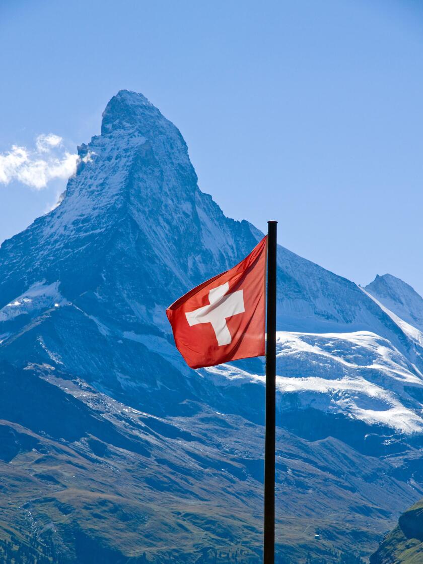 swiss flag in front of the matterhorn