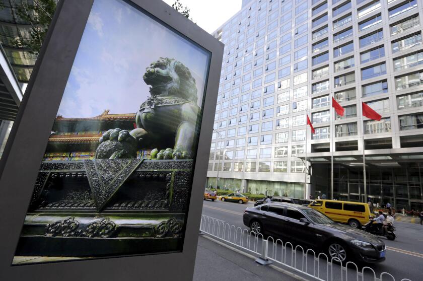 An advertising board (L) showing a Chinese stone lion is pictured near an entrance to the headquarters (R) of China Securities Regulatory Commission (CSRC), in Beijing, China, September 7, 2015.   REUTERS/Jason Lee/File Photo