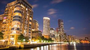 A skyline view of office and condominium towers along The Canary Wharf pier and neighbourhood at dusk.  The Thames River, London UK.