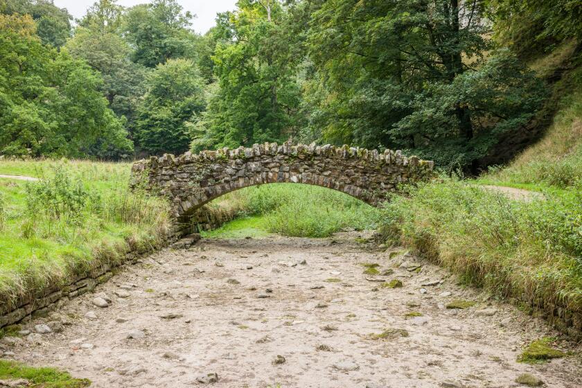 Stone bridge over a dried up riverbed. Drought in Seven Bridges Valley, North Yorkshire, England, UK