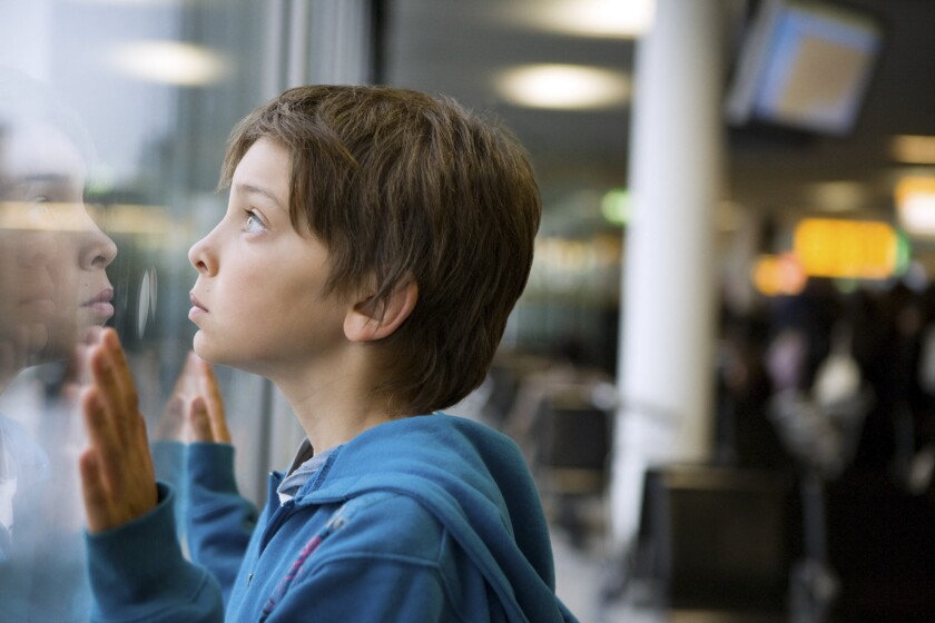 Young boy looking through a window
