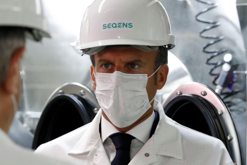 French President Emmanuel Macron, wearing a protective face mask, visits a site of pharmaceutical group Seqens, a global leader on the production of active pharmaceutical ingredients, to mobilize innovation and support the research on the coronavirus dise
