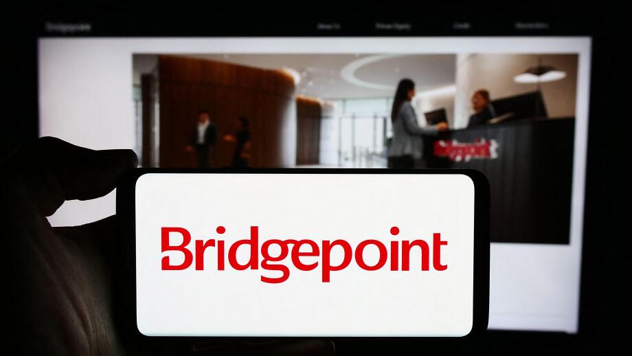 Person holding cellphone with logo of British investment company Bridgepoint Group plc in front of business webpage. Focus on phone display.