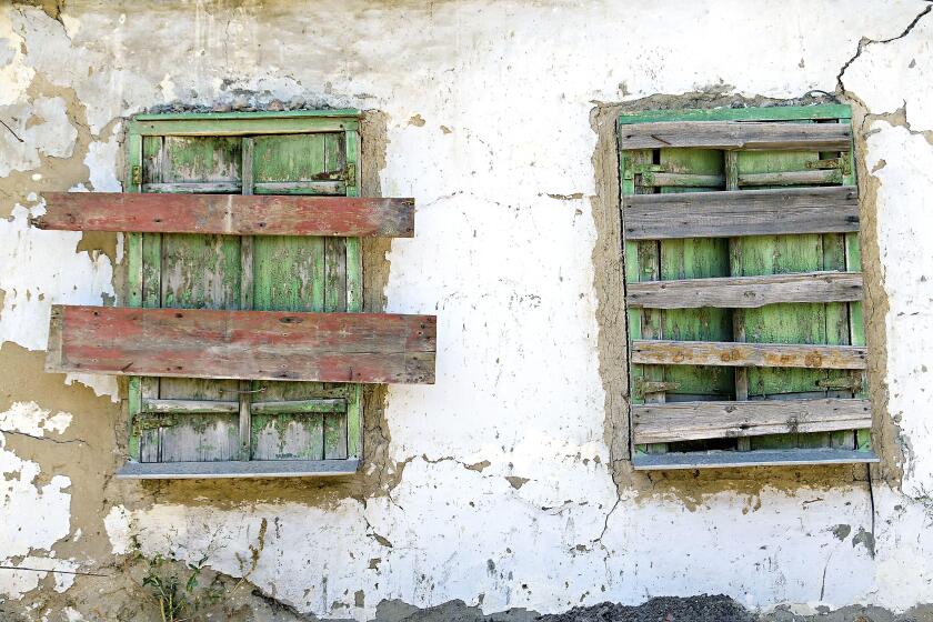 two old boarded-up window on the wall. Image shot 10/2019. Exact date unknown.
