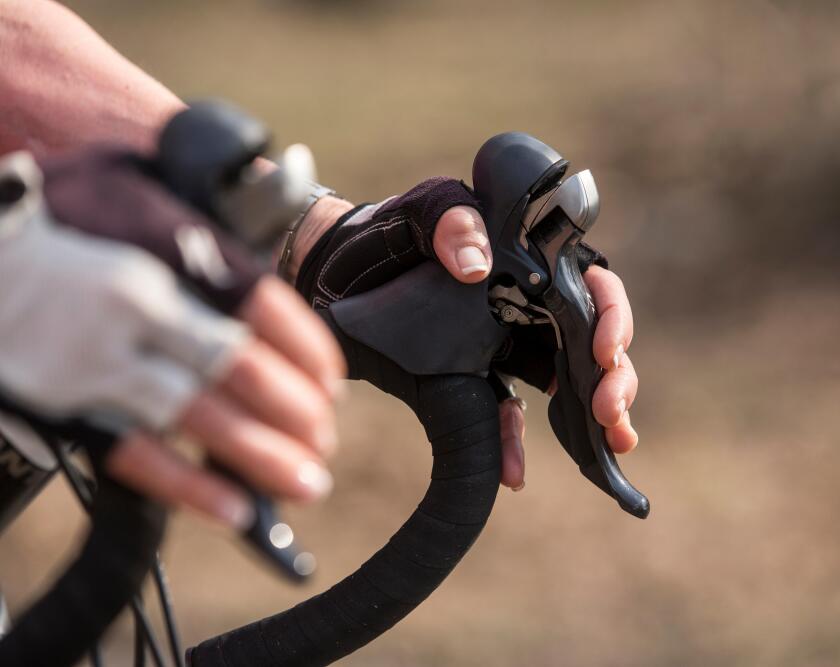 Young woman's hands on the brakes of a road bike