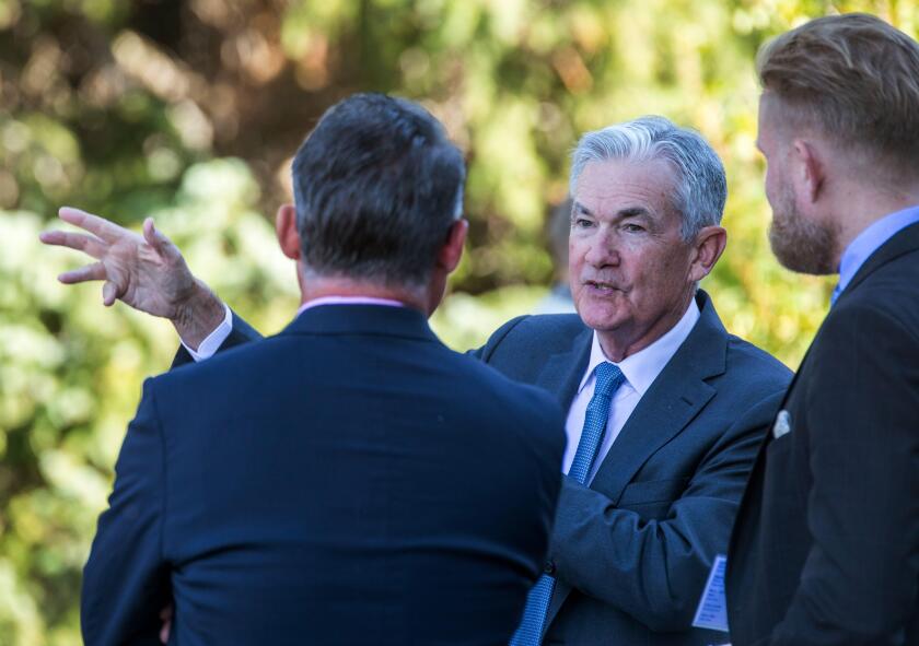 File - Federal Reserve Chair Jerome Powell, center, talks with attendees of the central bank's annual symposium at Jackson Lake Lodge in Grand Teton National Park, Aug. 26, 2022. in Moran, Wyo. As Powell returns to Jackson Hole this week, the U.S. economy