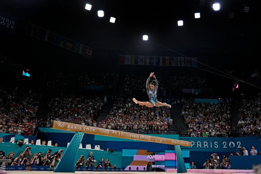 Simone Biles of the United States competes on the balance beam during a women's artistic gymnastics qualification round at the 2024 Summer Olympics, Sunday, July 28, 2024, in Paris, France. (AP Photo/Charlie Riedel)