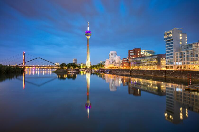Dusseldorf, Germany. Cityscape image of Dusseldorf, Germany with the Media Harbour and reflection of the city in the Rhine river, during twilight blue