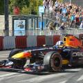Former F1 driver David Coulthard driving the Red Bull Racing RB7 Formula 1 car during the Red Bull Showrun in Budapest, with crowds and photographers