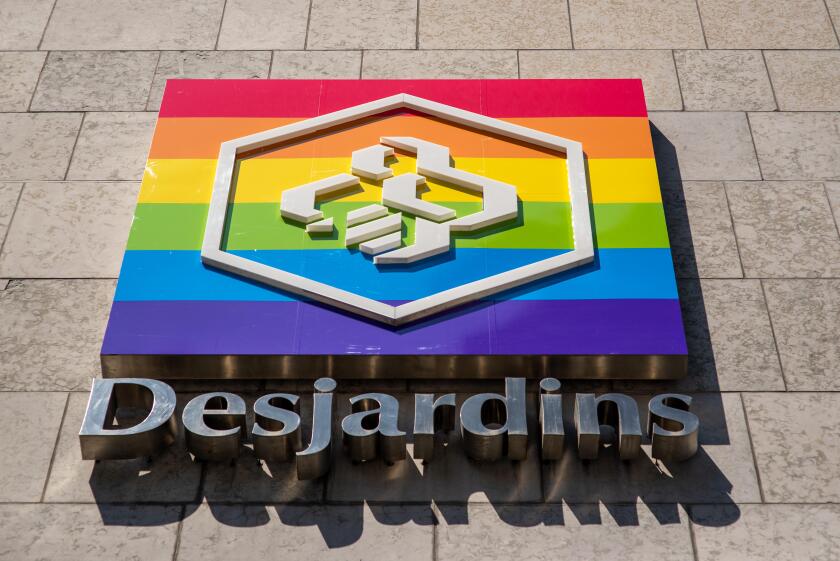 Montreal, Canada - August 6, 2019: Desjardins Credit Unions sign on headquarter building exterior wall with rainbow flag. Landscape format