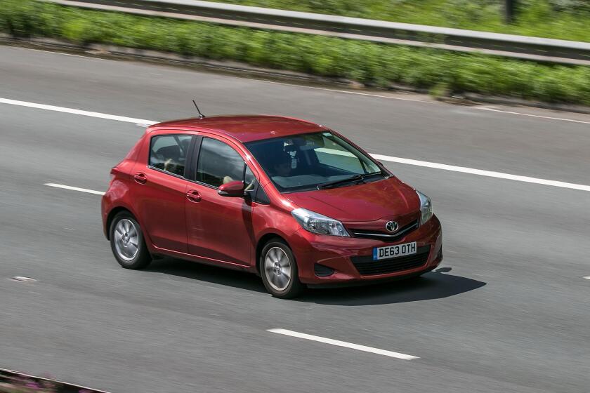 A 2013 Toyota Yaris Tr Vvt-I Red Car Hatchback Petrol driving on the M6 motorway near Preston in Lancashire, UK