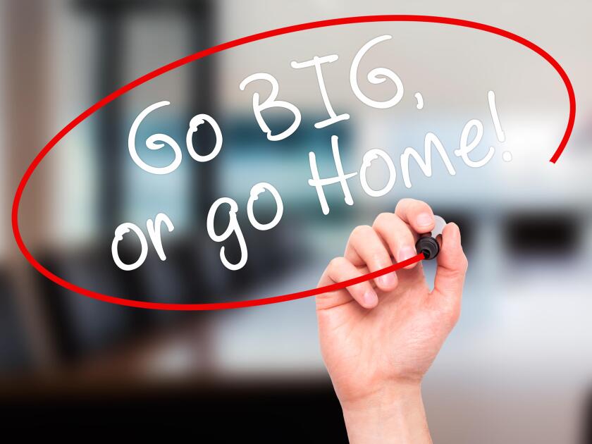 Man Hand writing Go Big or Go Home with black marker on visual screen. Isolated on office. Business, technology, internet concept. Stock Image
