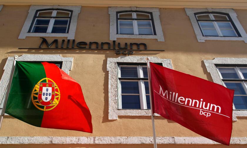 The Millennium BCP flag and the Portugal's flag are seen at the bank headquarters in Lisbon February 3, 2012. The largest listed banks by assets, Millennium BCP, should post a net loss of between 560 millions euros ($739 million) and 954 million, accordin