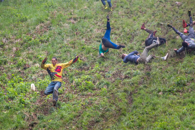 Gloucester, UK. The annual cheese rolling race held at Coopers Hill, Brockworth outside Gloucester. Competitors race down the extremly steep slippery hill chasing a double Gloucester cheese, the winner of each race recieves the cheese as thier prize.