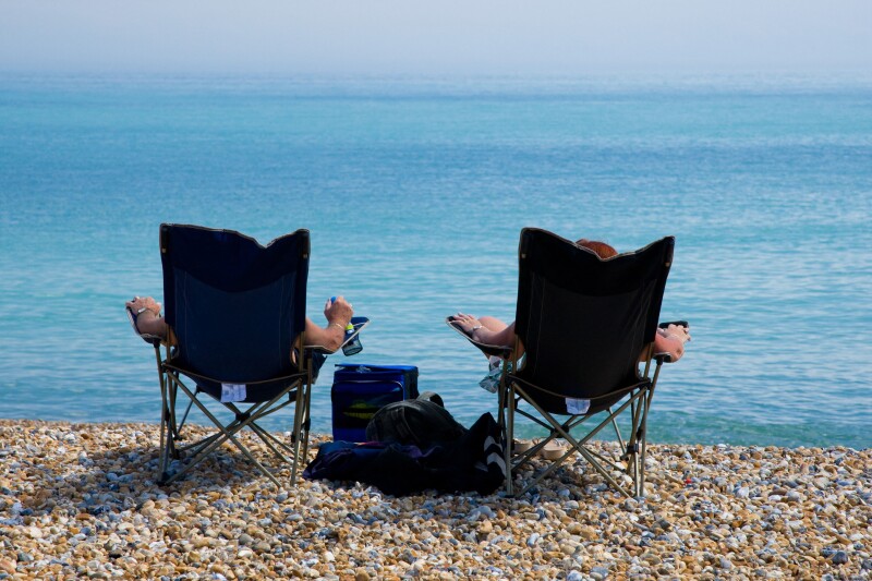 Two people soak up the sun on the beach