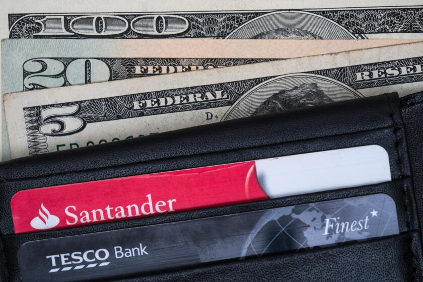 Wallet containing Santander and Tesco bank cards, and american dollars.