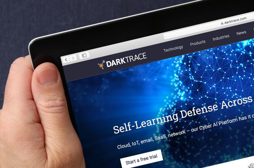 A man looking at the website for Darktrace a cyber-security developer on his iPad. (Editorial Use Only)