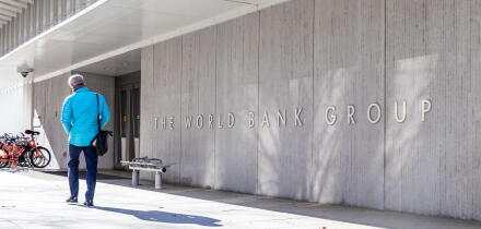 Man walks by a sign for The World Bank Group at their global headquarters in Washington, D.C.