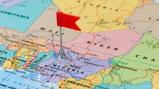 Photo of Nigeria marked by red flag in holder. Country on African continent.