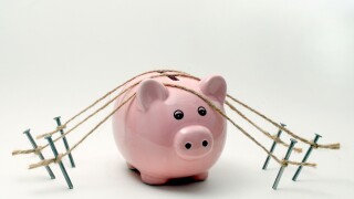 A PIGGY BANK  SECURED WITH ROPE AND NAILS RE SECURE BANKING,BANKS,SAFE,FINANCE SAVINGS THE ECONOMY WAGES MONEY RECESSION CASH UK