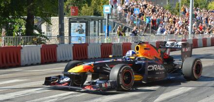 Former F1 driver David Coulthard driving the Red Bull Racing RB7 Formula 1 car during the Red Bull Showrun in Budapest, with crowds and photographers
