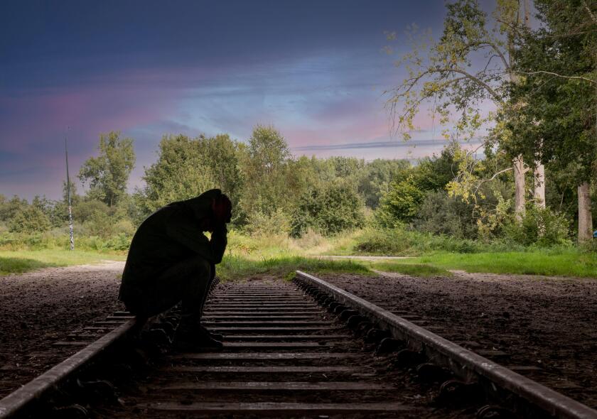 man sitting on a railway track