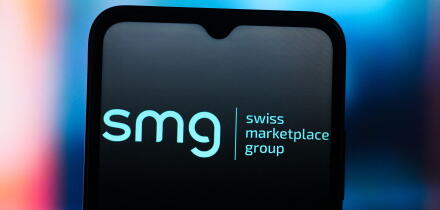 In this photo illustration, the SMG Swiss Marketplace Group logo is seen displayed on a smartphone screen.