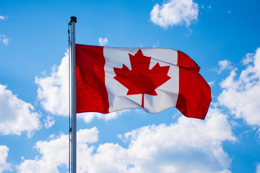 Canadian flag waving in the blue sky