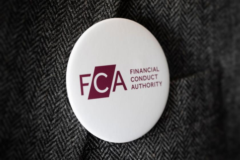 A button badge bearing the logo of FCA Financial Conduct Authority fastened to a suit jacket.