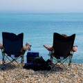 Two people soak up the sun on the beach