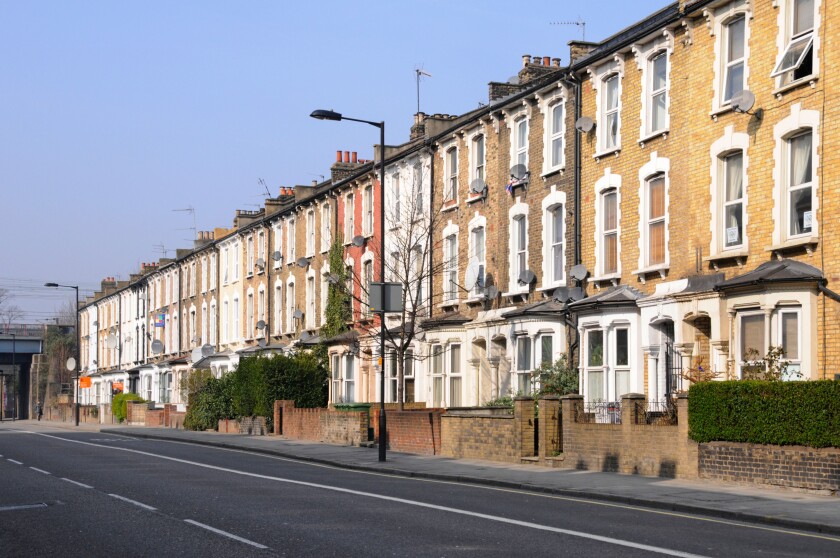 Long row of old three storey terraced flats & apartments without parked cars in Hackney London close to town centre & train station England UK
