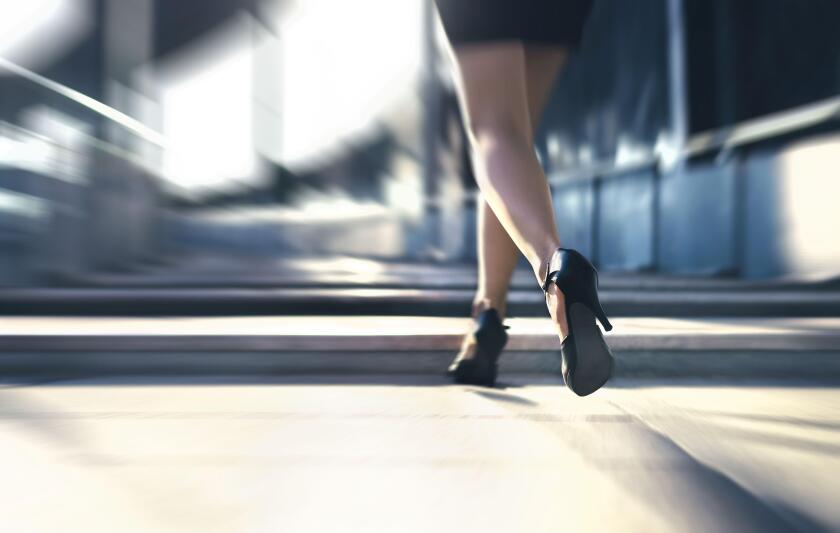 Woman running away or walking fast with high heels in city street. Busy business person in hurry. Late from work or stress fast. Sprint stairs.