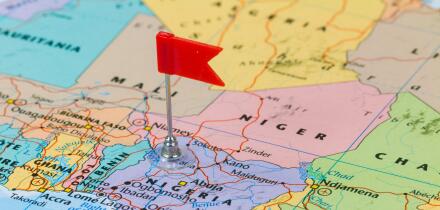 Photo of Nigeria marked by red flag in holder. Country on African continent.