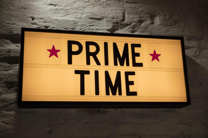 Close-up of Prime Time signboard against gray wall