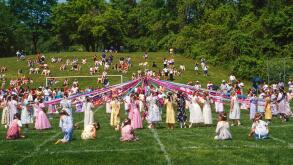 Elementary school children dancing around the May Pole; May Day